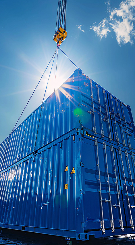 Blue container being lifted by crane in sunlight